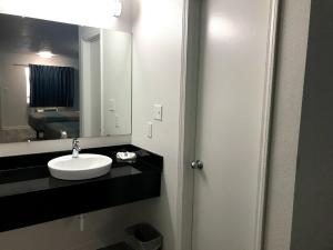 y baño con lavabo y espejo. en Motel 6-Metropolis, IL, en Metropolis