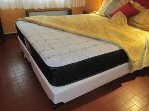 a bed with a yellow blanket on top of it at Cerca de Todo in Miramar