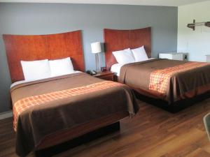 two beds in a hotel room with two beds at Travel Inn and Suites in Lakehurst