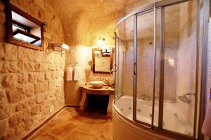 a bathroom with a shower and a sink and a tub at Miras Hotel in Göreme