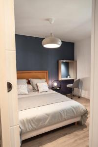 - une chambre avec un lit et un mur bleu dans l'établissement Le joyau de Belledonne, à Chambéry