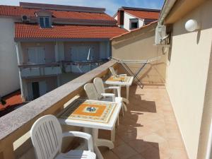 a balcony with tables and chairs on a building at Apartments Novalja in Novalja