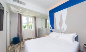 a bedroom with a white bed with a blue headboard at Garden Suite in Marina di Pietrasanta