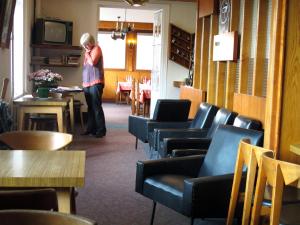 een vrouw in een kamer met tafels en stoelen bij Hotel Restaurant - Acacias Bellevue in Veyrier-du-Lac