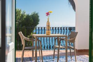 un tavolo con sedie e un vaso sul balcone di Villa Mallandrino a Mondello