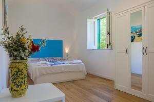 um quarto com uma cama e um vaso com flores em Villa Mallandrino em Mondello