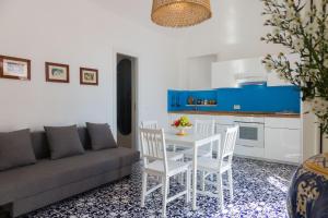 un soggiorno con divano, tavolo e sedie di Villa Mallandrino a Mondello