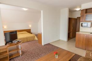 a hotel room with a bed and a television at Hotel Genada in Sveti Vlas