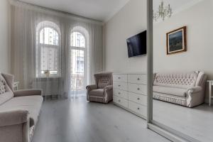 uma sala de estar com um espelho, um sofá e uma cadeira em Lux Apartments In The Center em Lviv