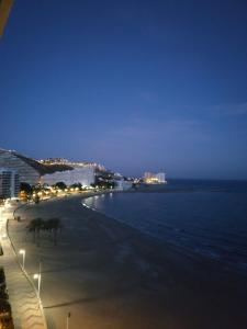 a beach at night with buildings and the ocean at Descans in Cullera