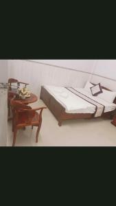 a bedroom with a bed and a table and a chair at Minh Minh Hotel in Quy Nhon