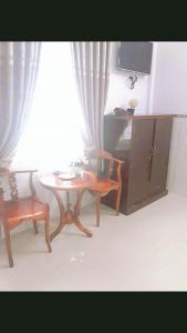 a living room with a table and chairs and a tv at Minh Minh Hotel in Quy Nhon