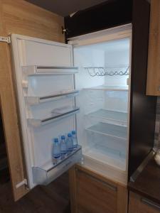 an open refrigerator with bottles of water in it at Liptov Odessa in Liptovský Mikuláš +7 photos