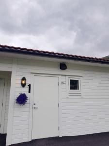 un garaje blanco con puerta y ventana en Saltvold leilighet nr1 en Røldal