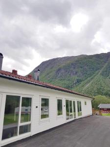 a white house with a mountain in the background at Saltvold leilighet nr1 in Røldal