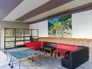 Habitación con mesa de ping pong y bancos en Hostel „La Galan”, en Rădăuţi