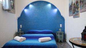 a blue bedroom with a bed and two tables at Riad Les Chtis D'Agadir in Agadir