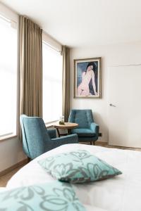 - une chambre avec deux chaises, un lit et une table dans l'établissement Maison de la Paix, à Poperinge