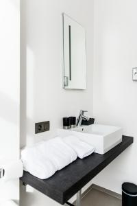 uma casa de banho com um lavatório branco e um espelho. em Maison de la Paix em Poperinge