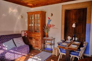 ヴィーラ・ノーヴァ・デ・ポイアレスにあるA Charming , Traditional Cottage at Quinta da Ribeiraのリビングルーム(ソファ、テーブル付)