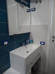 y baño con lavabo blanco y espejo. en CVT Punta Cavalluccio, en Vasto