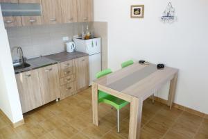 a kitchen with a wooden table and green chairs at Clementine in Sveti Stefan