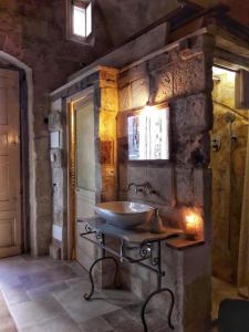 a bathroom with a sink in a stone wall at Cave Rooms Sassi in Matera