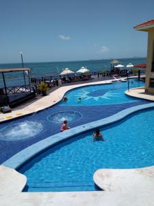 una piscina con gente junto al océano en Beautiful condo a few stps to sea, en Cancún