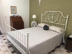 a bedroom with a white bed with a black bag on it at Maria Maddalena Holiday House in Vico Equense