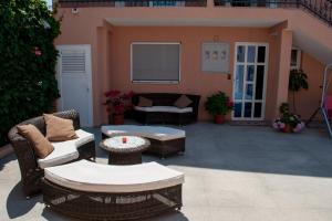 a patio with wicker chairs and a couch and a table at Apartments Villa Sveti Nikola in Budva