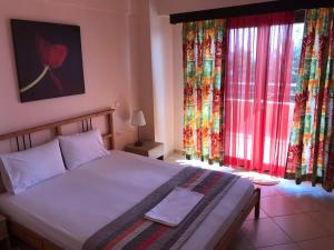 a bedroom with a bed and two large windows at Alba Mare Kallithea in Kallithea Halkidikis