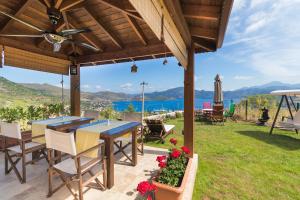 een patio met een tafel en stoelen en uitzicht op de oceaan bij Harmanyeri Tatilevi in Selimiye