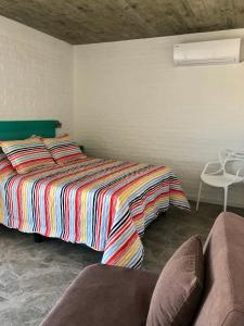 a bedroom with a bed with a colorful blanket at Las Olas Aparts in La Paloma