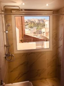 łazienka z oknem z widokiem na budynek w obiekcie Metis Athens Suites w Atenach