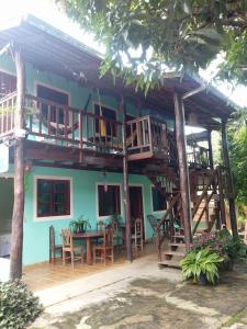 a house with a wooden deck and a table and chairs at Pousada Nenzinha in Sao Jorge
