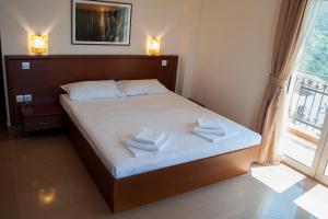 a bedroom with a bed with two towels on it at Apartments Villa Sveti Nikola in Budva