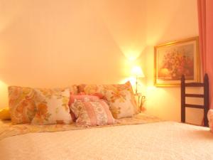 um quarto com uma cama com almofadas em B&B Italia em Milis