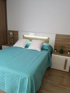 ein Schlafzimmer mit einem blauen Bett mit zwei Kissen in der Unterkunft Lux Home in Albufeira