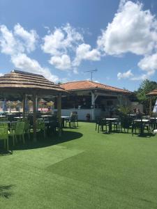 eine Terrasse mit Tischen und Stühlen und ein Gebäude in der Unterkunft MOBIL HOME 43 dans Camping 4 Etoiles in Gastes
