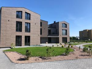 a large brick building with a garden in front of it at Vila JŪRALUX in Palanga