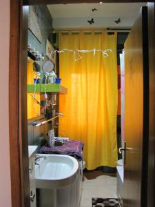 a bathroom with a sink and a yellow shower curtain at Cozy!! Verona in Verona