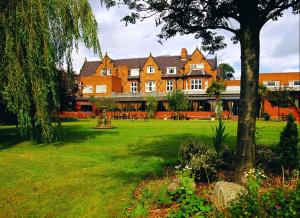a large building with a lawn in front of it at Brook Mollington Banastre Hotel & Spa in Chester