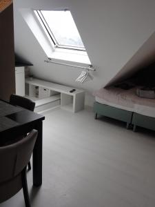 Cette chambre mansardée comprend un lit et une lucarne. dans l'établissement Pension Corper, à Zandvoort