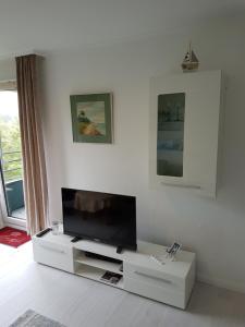 a living room with a flat screen tv on a stand at Ferienwohnung Strandliebe in Glücksburg