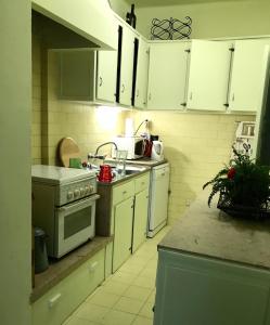 uma cozinha com armários brancos e um fogão em A casa do bairro em Lisboa