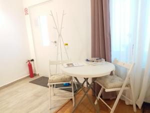 mały biały stół i krzesła w pokoju w obiekcie Republicii Residence w Braszowie