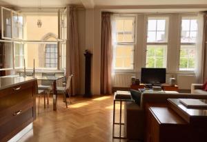 プラハにあるSpacious elegance in the heart of Old Townのリビングルーム(テーブル付)、窓付きのキッチンが備わります。