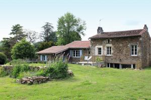 Gite La Grange de Jeanne في Rancon: منزل حجري قديم على حقل عشبي