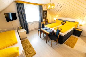 ein Schlafzimmer mit einem Bett und einem Tisch sowie ein Esszimmer in der Unterkunft Gasthaus Tannenhof in Lütz