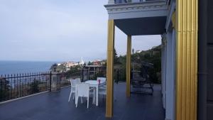 a balcony with a table and chairs and the ocean at EYLA VİLLA in Trabzon